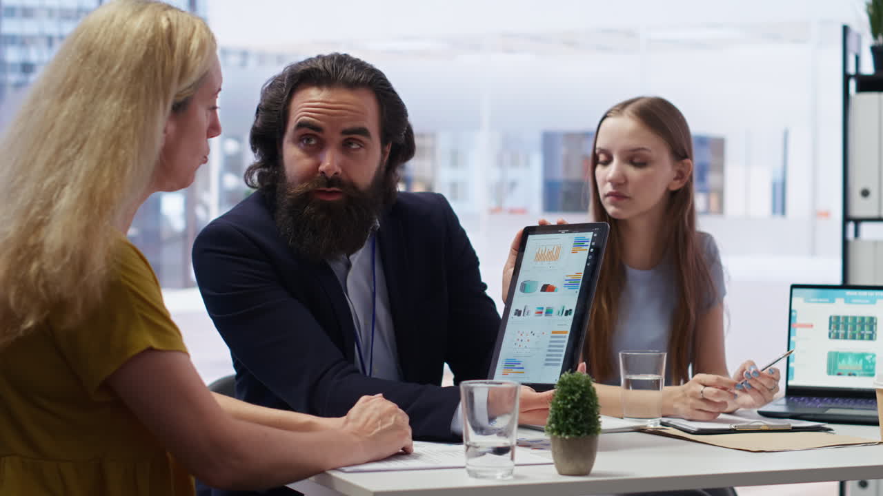 asesor financiero que muestra gráficos estadísticos en una tableta a los clientes