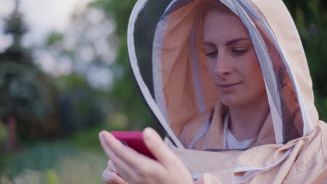 Eine-Frau-Im-Imkerkostüm-Kauft-Online-Per-Smartphone-Einen-Neuen-Bienenstock