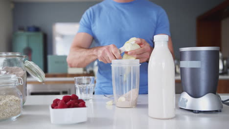 primer plano de un hombre haciendo un batido de proteínas después de hacer ejercicio en casa