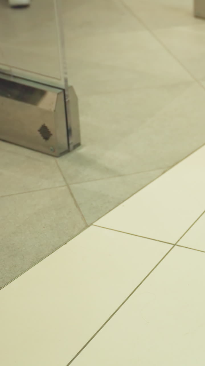 una vista en primer plano de los pies de las personas moviéndose en un centro comercial, mostrando la parte inferior del cuerpo y el calzado. disparado desde la perspectiva de primera persona con una cámara de mano