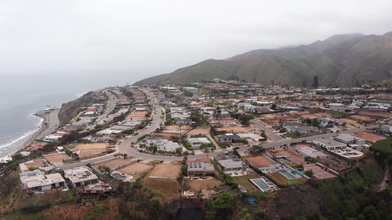 Rising aerial dolly shot of cleared residential lots in the upscale Sunset Mesa neighborhood after the Palisades Fire in Malibu, California. 4K