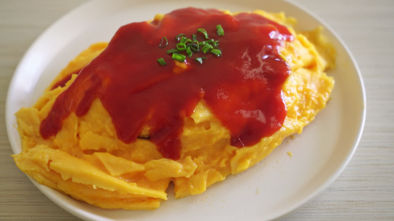 arroz frito aromatizado en una envoltura de tortilla o omurice al estilo japonés - estilo de comida asiática