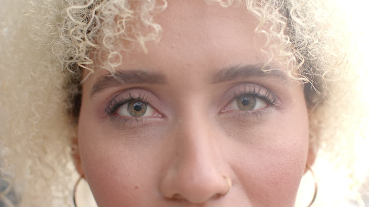Close-up of woman's eyes with curly hair, focusing on facial features