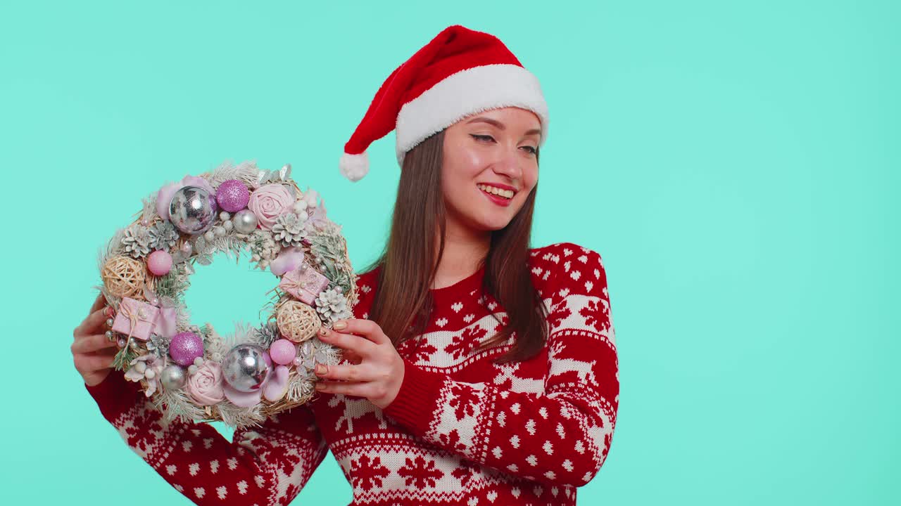 은 크리스마스 휴일 스웨터를 입은 미소 짓는 성인 소녀 축제 꽃받침 장난감에 손가락을 올리십시오