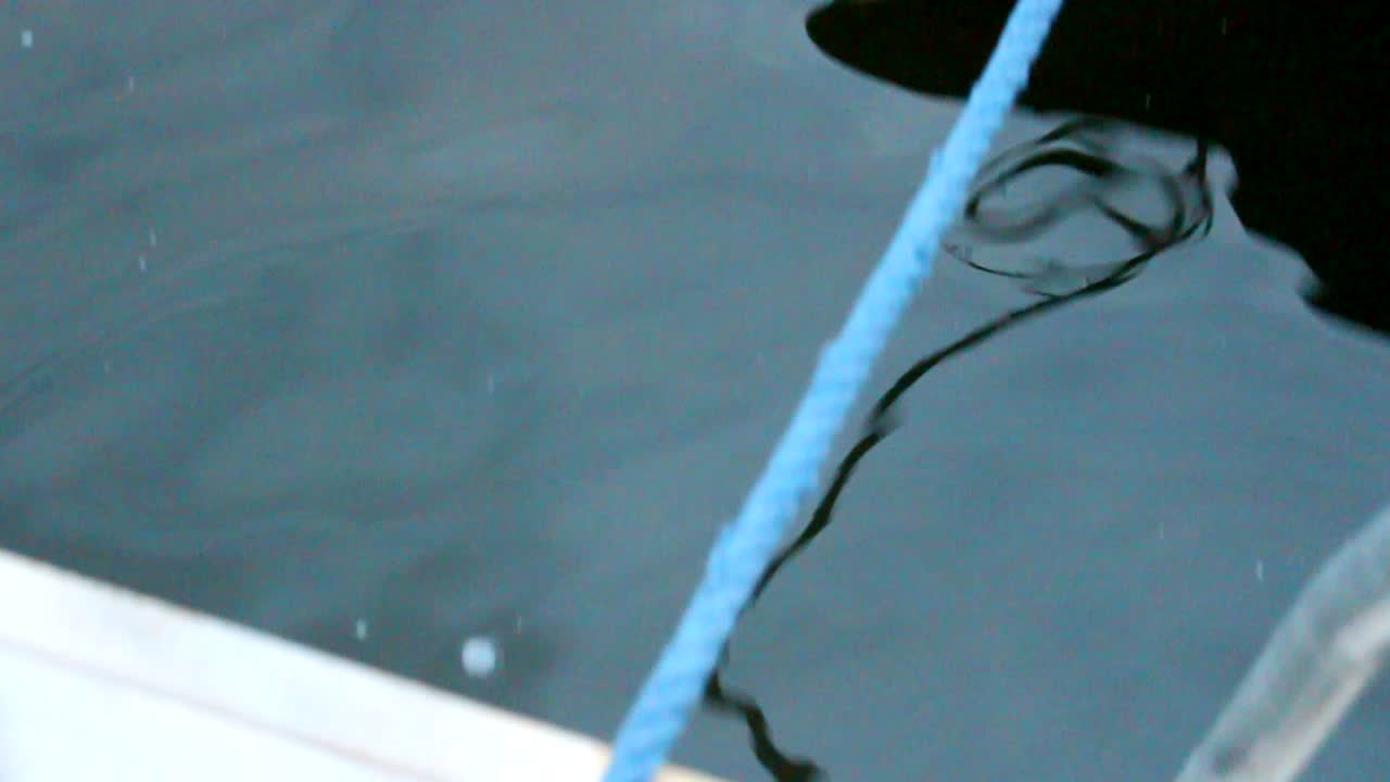 moderno barco a motor amarrado al muelle, cuerda azul, olas tranquilas, atracado y atado