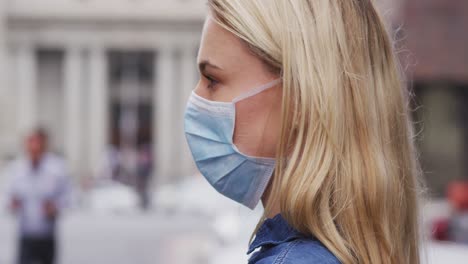vista lateral de una mujer caucásica con una máscara de coronavirus covid19
