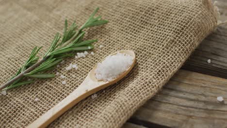 video of rosemary twig and spoon of salt on wooden background