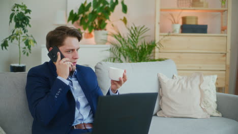 Relaxed-Businessman-Talks-and-Drinks-Coffee