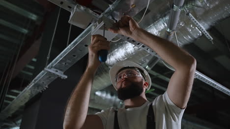 electrician installing/repairing ceiling lighting