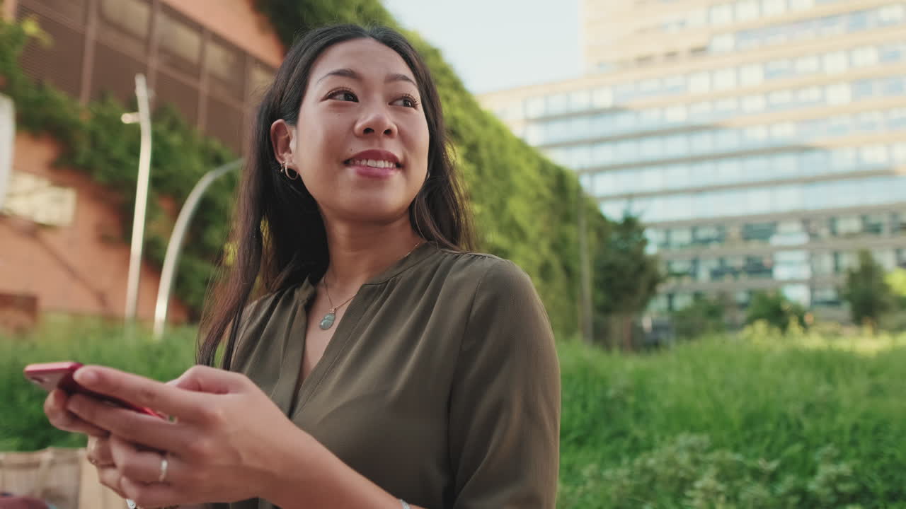 Asian woman using phone outdoors