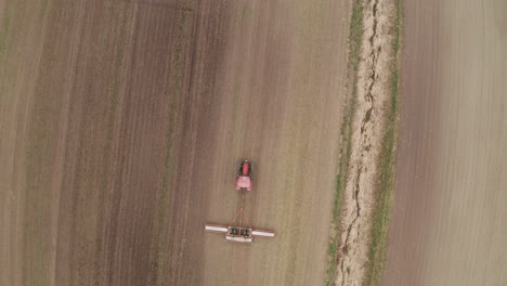 vista aérea desde un dron mirando hacia abajo en la máquina de remolque del tractor en el campo