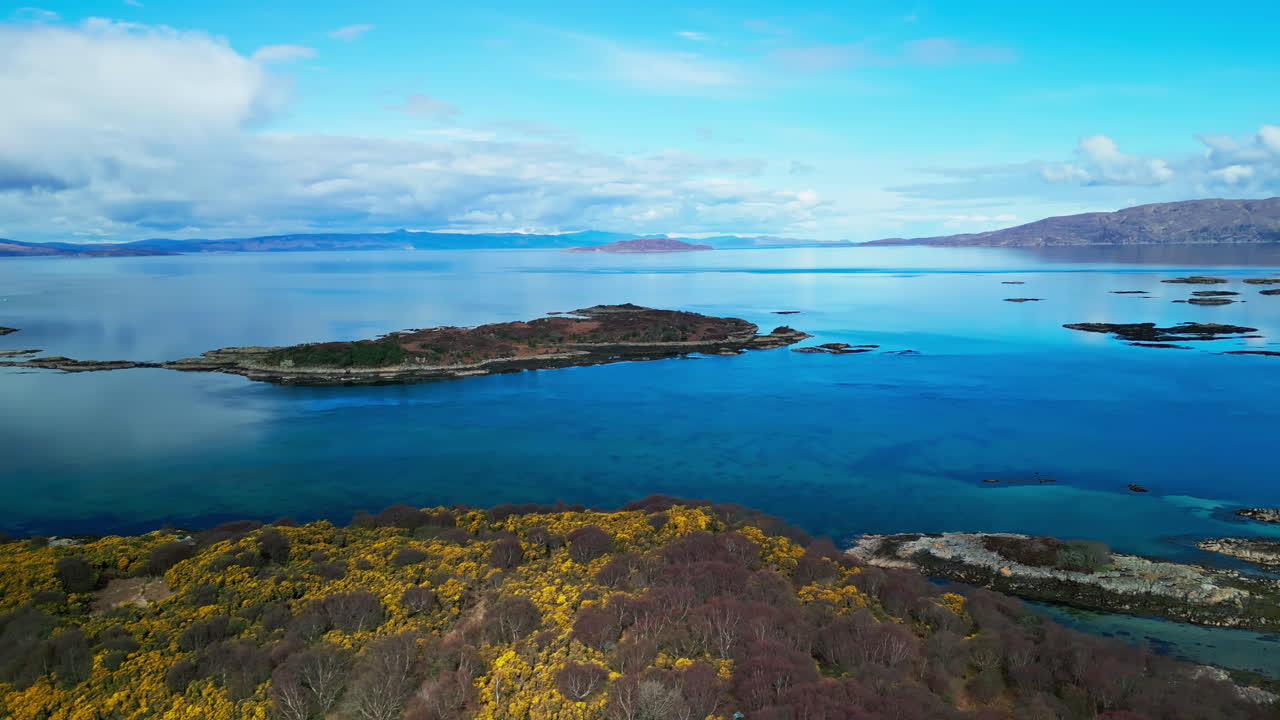 항공 트럭  ⁇ 이 기울어져 활기찬 노란색  ⁇ 과 스카이 섬 스코틀랜드의 깊은 파란색 물을 드러 ⁇ 니다.