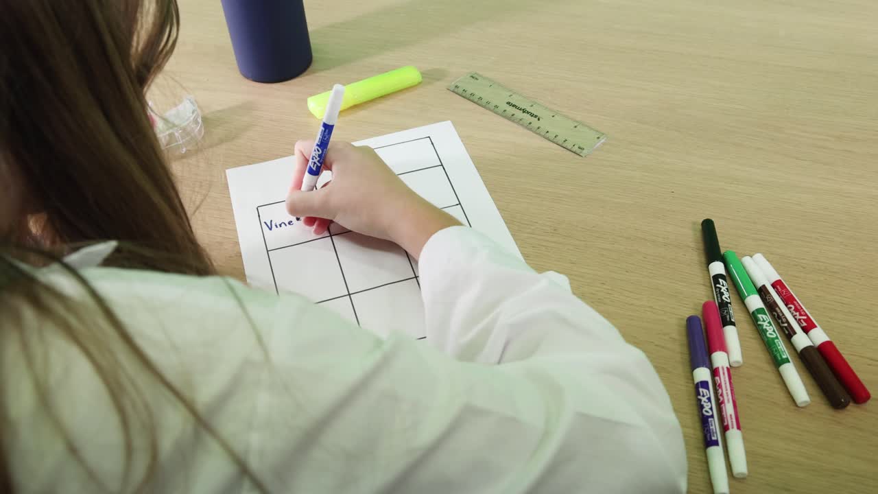 persona que escribe en un papel de cuadrícula