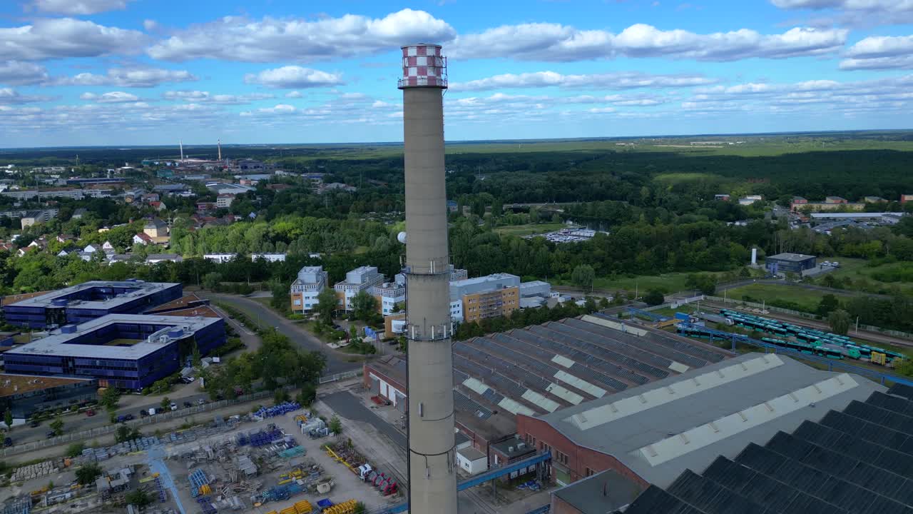 Hennigsdorf steel industry with industrial buildings, chimneys, storage area and a river in the background. Perfect aerial view flight fly push forward drone