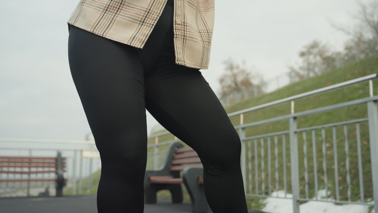 Detaljerede dansetrin. Fodarbejde, der inkluderer hæl- og tåtap. Rytmiske fodmønstre på byfortovet med gelænder. Præcise dansebevægelser, der fremhæver ankelkontrol i urbane omgivelser.