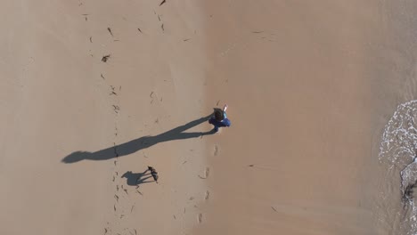 Top View Of A Lone Man Walking On Sandy Shores Of Praia do Lago In A Coruña, Spain. Aerial Shot