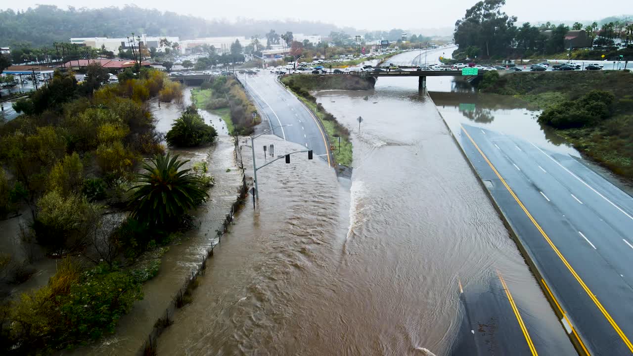 캘리포니아 주 샌디에이고의 고속도로 오프램프를 따라 파이프와 오버플로우에서 물이 흘러나옵니다.