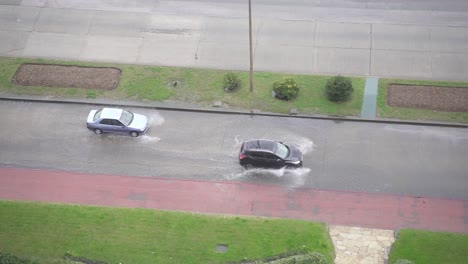Zwei-Autos-Fahren-Auf-überfluteten-Straßen-Und-Spritzen-Wasser,-Handortung