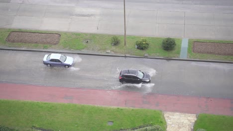 two cars driving on flooded roads and splashing the water, handheld tracking