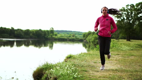 a morning jog in the park near the pond in the sunny rays of dawn, the girl is preparing to mariano and lead a healthy lifestyle