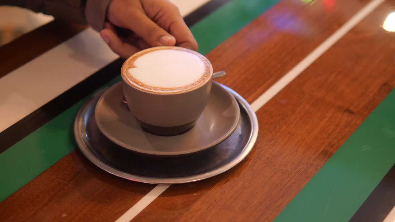Person holding a cup of cappuccino