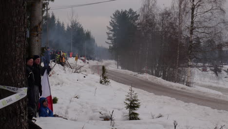 rally car approaching on a small winter road.