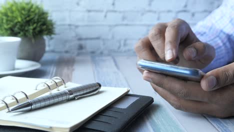 persona que utiliza un teléfono inteligente en un escritorio