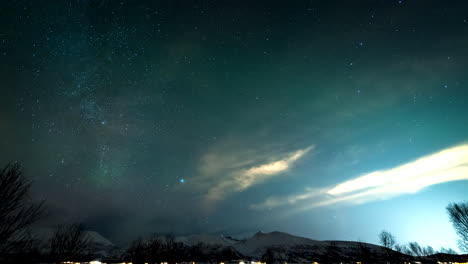 night sky timelapse over broskar in norway, vibrant strand clouds reflecting light illuminating the winter landscape