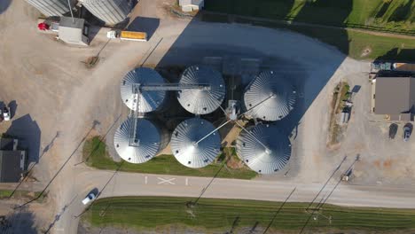 ascending drone flight over a farm with many steel silos to store cereals or grain for domestic cattle