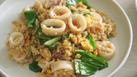 fried rice with squid or octopus in bowl - stir-fried rice with squid, egg and kale