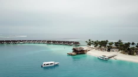 toma de drones, isla de maldivas, lado del puerto, villas de agua y yates, laguna azul y una mini jungla