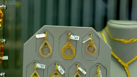 Im-Schaufenster-Des-Juweliergeschäfts-Liegen-Goldene-Ohrringe-Und-Schmuck