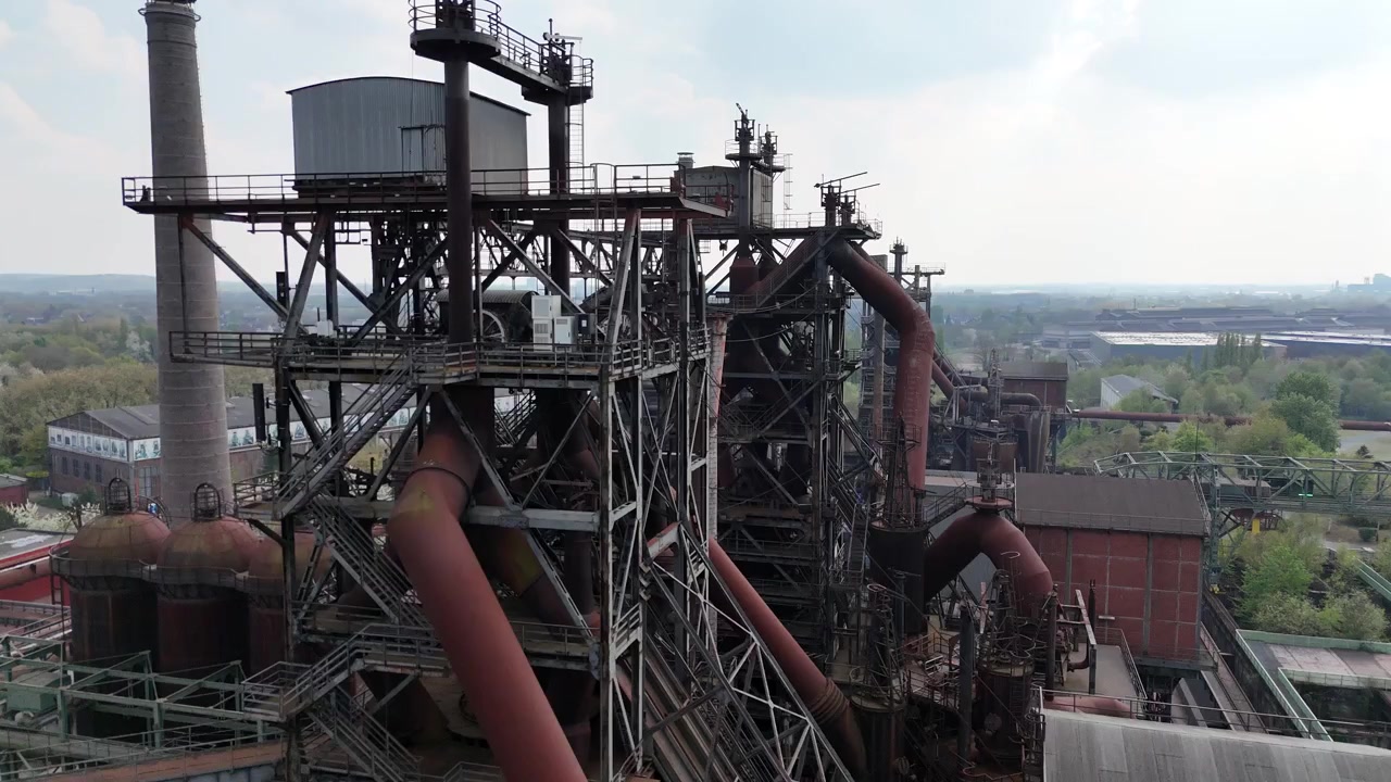 Schnelle Abwärtsbewegung einer Drohne, die ein cineastisches Industrieareal enthüllt