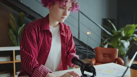 female employee with prosthetic arm typing on laptop at office desk