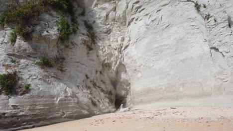 a high cliff of chalky stone eroded by the harsh typhoons in the andaman sea have formed a cave on the beach