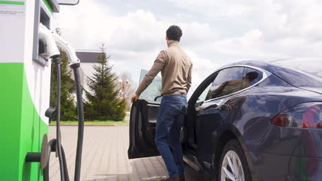 hombre saliendo de un coche eléctrico