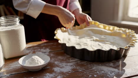 preparing a pie crust in a tart pan