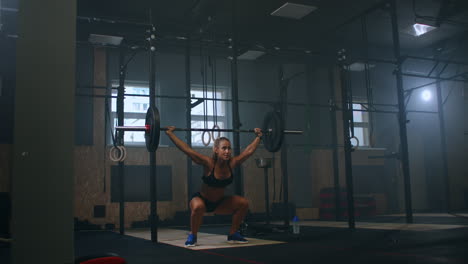 Cámara-Lenta:-Entrenamiento-De-Sentadillas-Con-Pesas-Sobre-La-Cabeza.-Mujer-Musculosa-Levantando-Barra-Sobre-Los-Hombros-De-Entrenamiento-De-Cabeza-En-El-Gimnasio.-Mujer-Segura-De-Fitness-Practicando-Entrenamiento-De-Fuerza-Con-Equipo-Pesado.