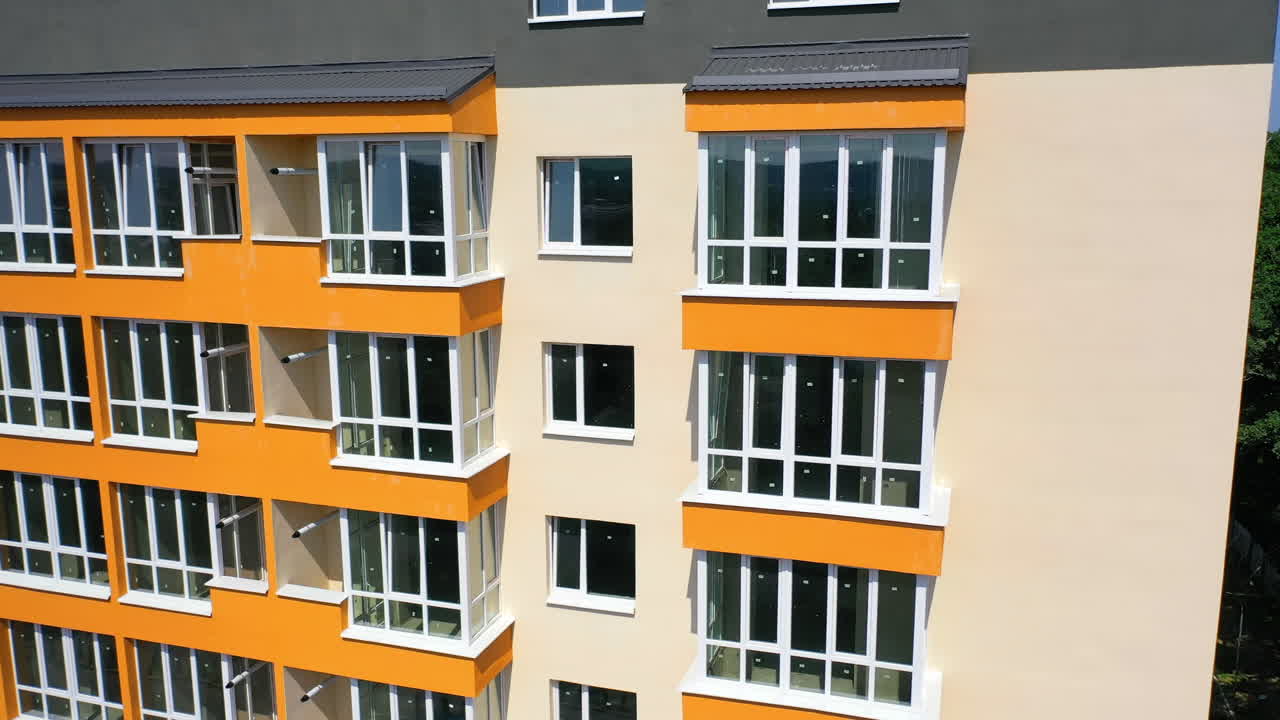 Boligområde med høje lejlighedsbygninger. Luftfoto af facaden på en nybygget moderne højhuslejlighedsbygning.