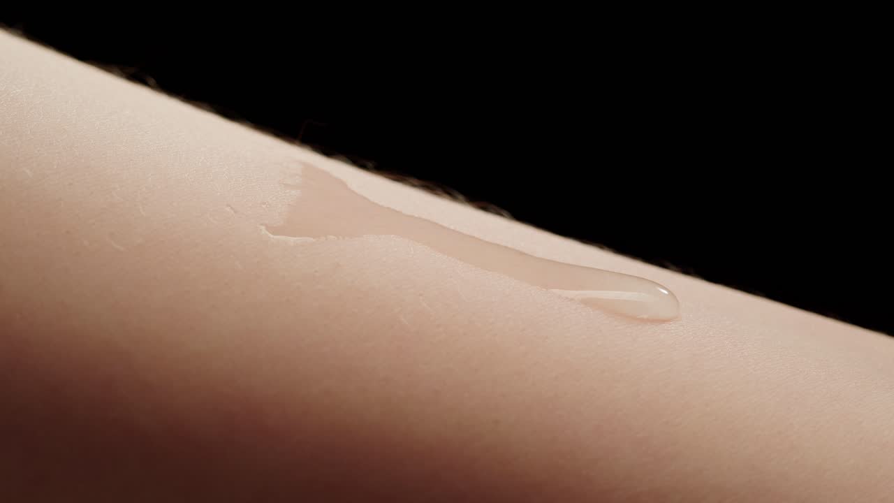 Gel Cair Bening Menyebar di Kulit Manusia dalam Gerak Lambat.