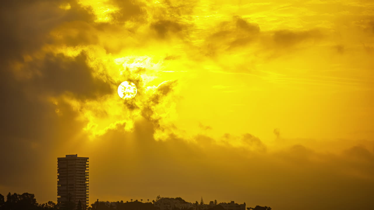 lapso de tiempo de las nubes de tormenta que se mueven frente al sol sobre málaga, españa