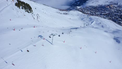 Luftaufnahme-Einer-Hochgebirgsskipiste-Mit-Skifahrern-Und-Skiliften,-Die-An-Einem-Sonnigen-Tag-Laufen