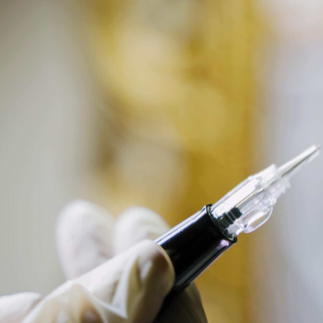 A beautician holds in her hand a pen for permanent makeup and checks it before the procedure. Close-up. Blurred background. Beauty industry.