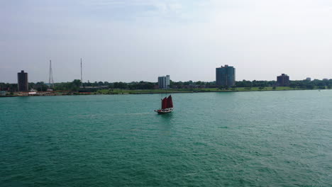 Aerial-view-passing-a-Schooner,-sailing-in-front-of-the-Windsor-city-in-Canada