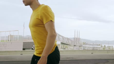 Epic-Portrait-and-close-upt-of-a-Young-Attractive-Trendy-Man-skateboarding-fast-under-a-solar-panel-on-a-morning-sunny-day-with-an-urban-city-background-in-slow-motion