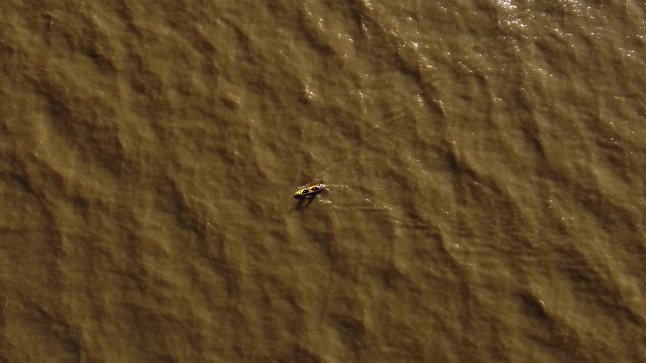 해질녘에 카약에서 노 젓는 두 명의 노 젓는 사람에 대한 공중 하향식 추적