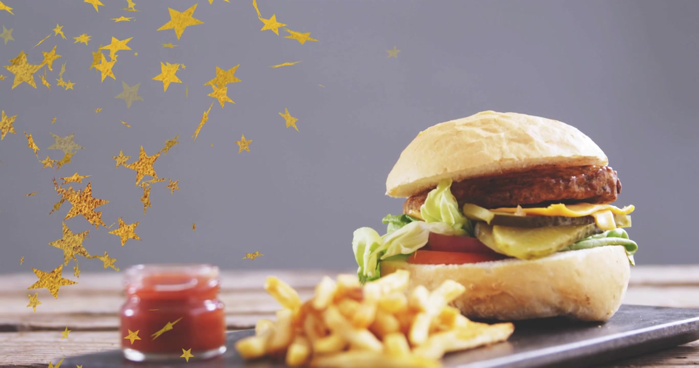 Coriandoli dorati che appaiono in alto a sinistra, fluttuando attraverso l'inquadratura, rivelando un hamburger e patatine fritte, aggiungendo un tocco di stile.