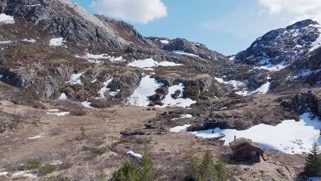 nieve en las laderas rocosas de las montañas con un lago congelado en leknes, vestvagoy, nordland, noruega