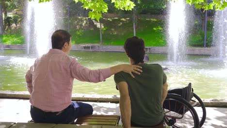 mature man listening to his physically disabled friend.