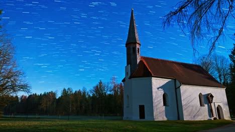 zoom out of a church at a starry night with star trails at the clear night - a short view into the universe and it's earth rotation